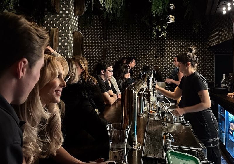 People enjoying the front bar at Asylum NYC, a comedy club in the city. 