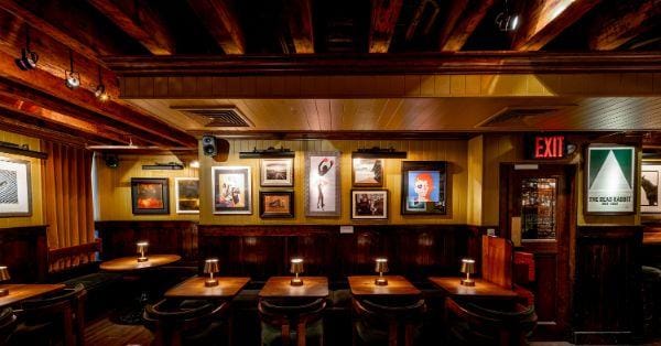 Seating area featuring a wide variety of artwork at The Dead Rabbit NYC, a bar for celebrating 21st birthdays in New York.