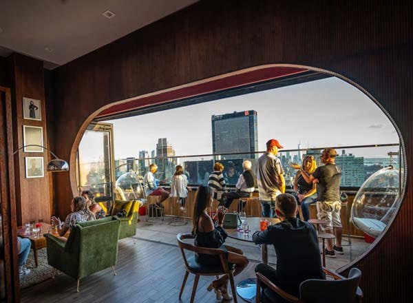 People drinking on an outdoor terrace at Dear Irving on Hudson, a bar for celebrating 21st birthdays in New York. 
