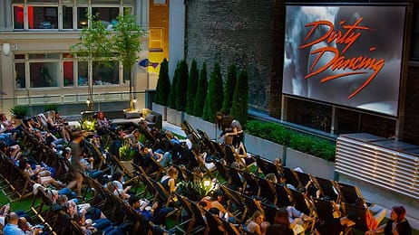 People enjoying a movie in the outdoor screening area at Rooftop Cinema Club Midtown, a unique party venue in NYC.